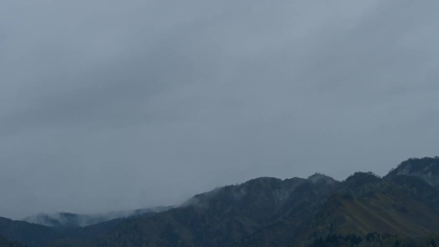 Clouds hang over mountain peaks