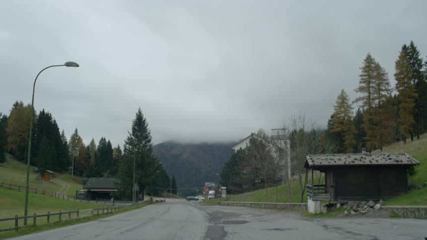Street lights on a rural road with fields and trees