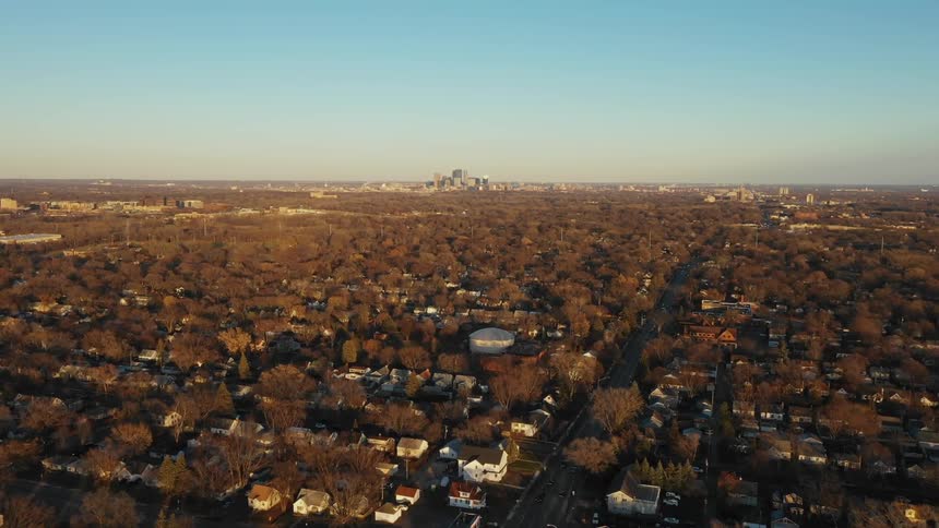 A city neighborhood is shown at sunrise