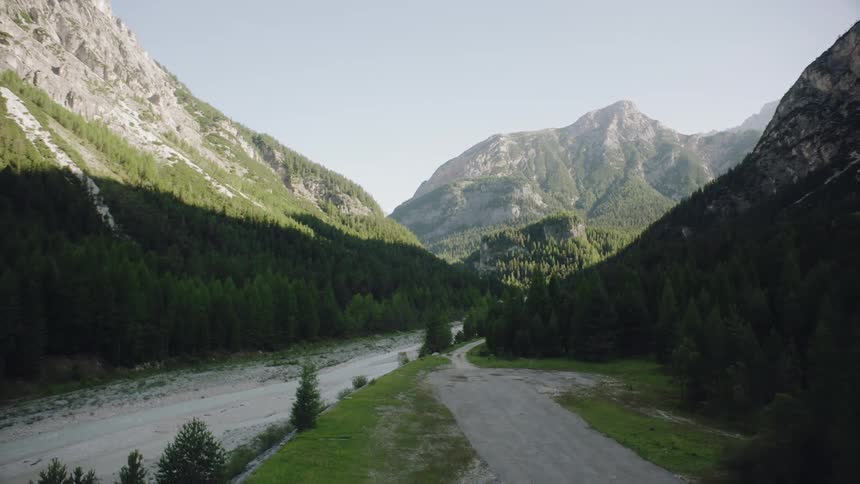 The mountains are vast with a trail going between them