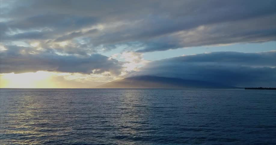 A storm is in the distance over the calm ocean