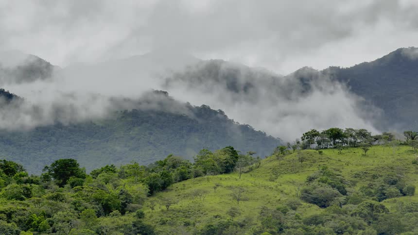Clouds rolling over green hills