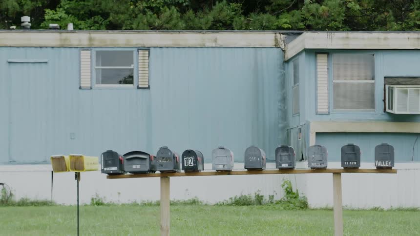 Row of mailboxes outside of a blue trailer