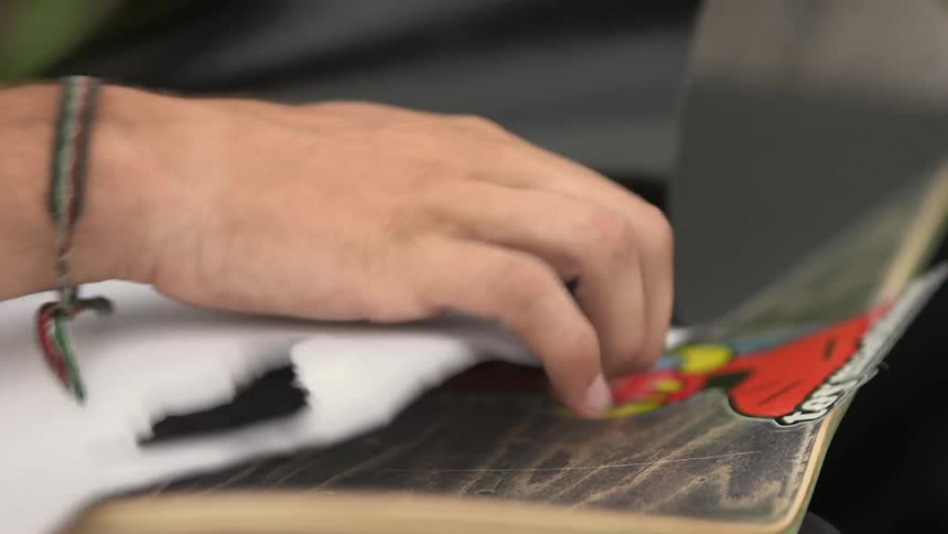 A person is preparing a skateboard