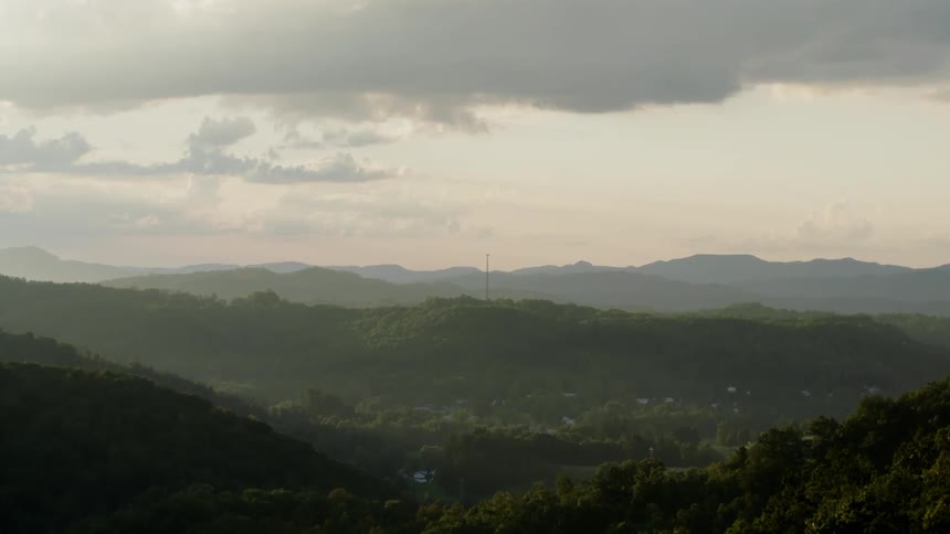 The mountain range ahead is covered with green