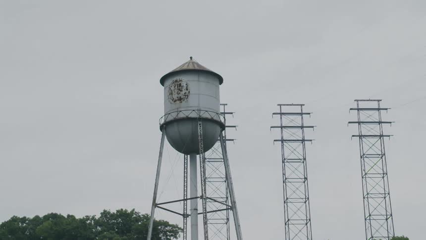 A water tower stands near power lines