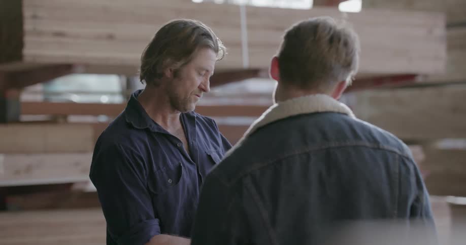 A man is talking to someone while holding a clipboard