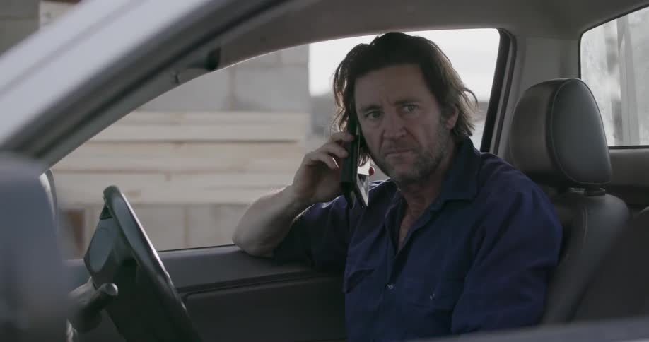 A man talks on a cell phone in a car
