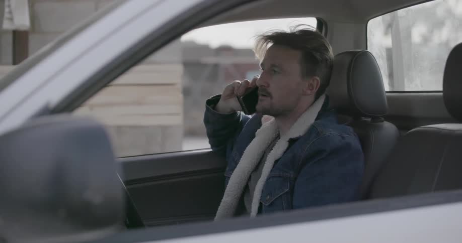 Man talks on a phone while sitting in a truck