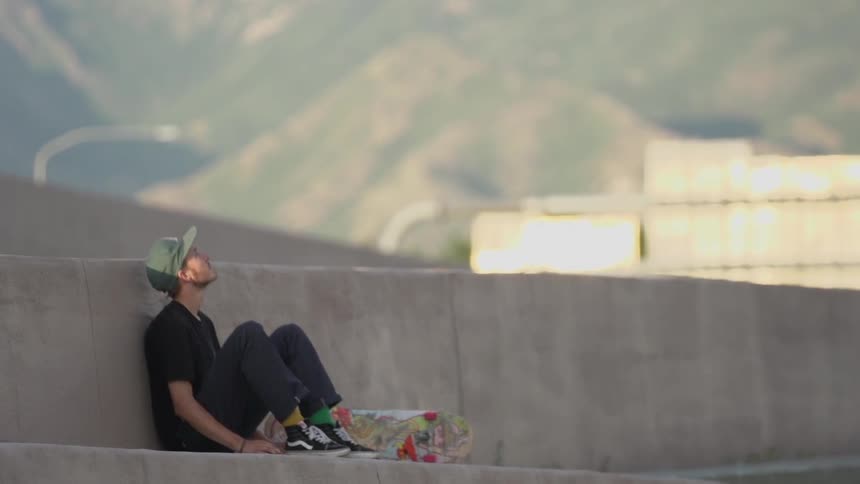 Man sitting with his skateboard on a sunny day
