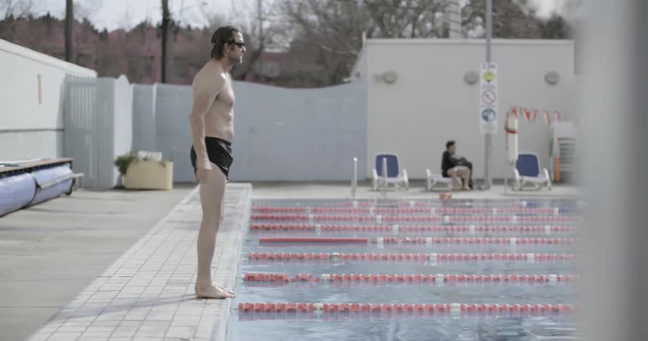 A man is diving into a swimming pool and swimming