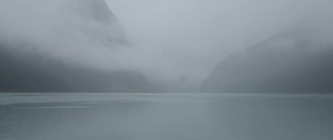 Fog hangs over the water and hills