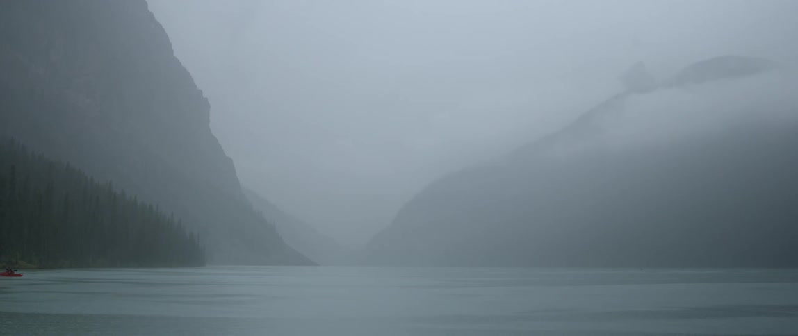 Body of water next to hills and mountains in a very hazy area