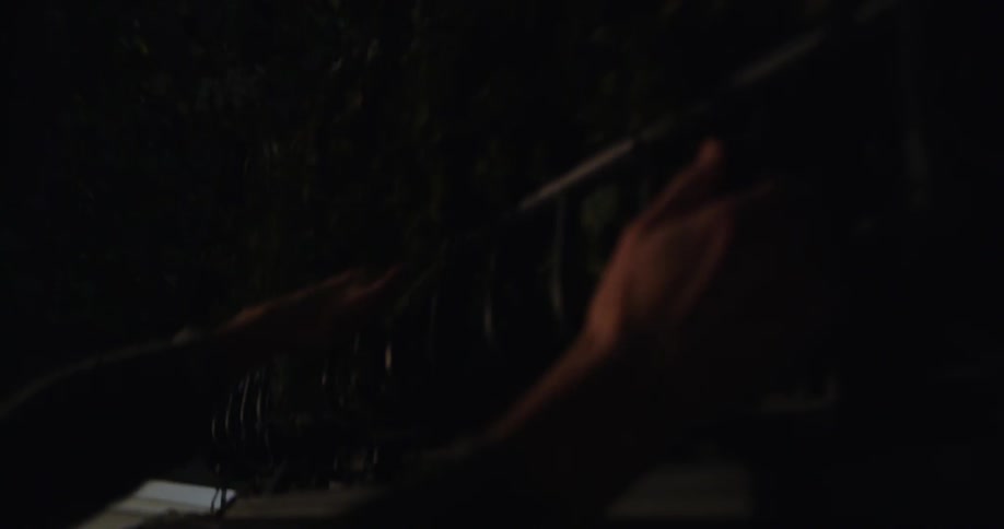 A man is getting out of his suv and untying the christmas tree on top at night