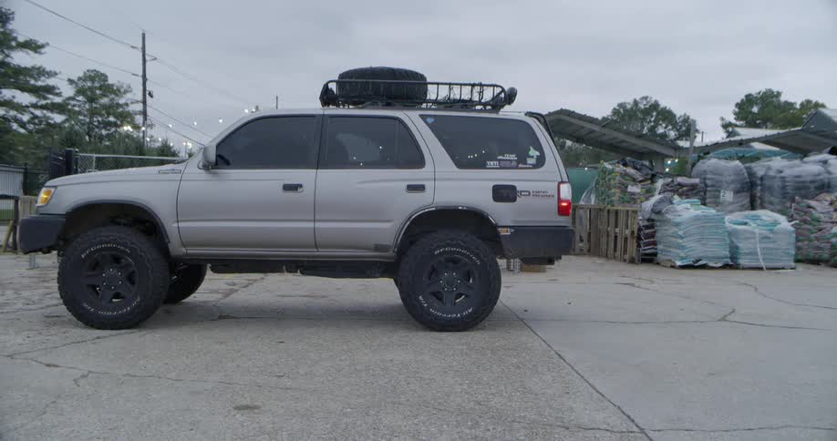 A man parks an suv and climbs out