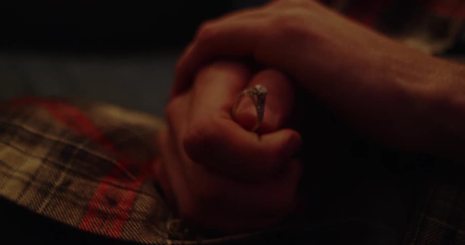 A man holds an engagement ring and fidgets