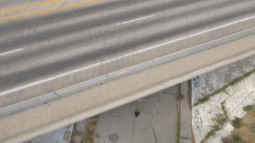 Aerial view of a person skateboarding down an empty road