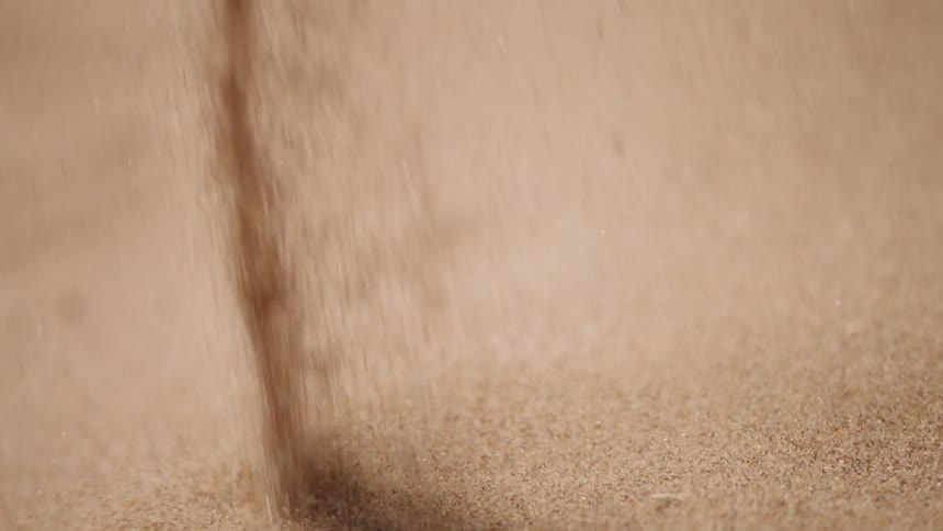 Sand is poured down into a pile