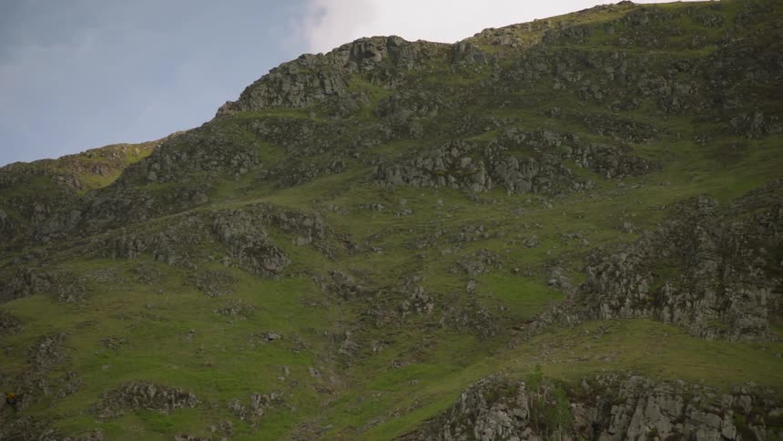 Clouds float above a mountainside