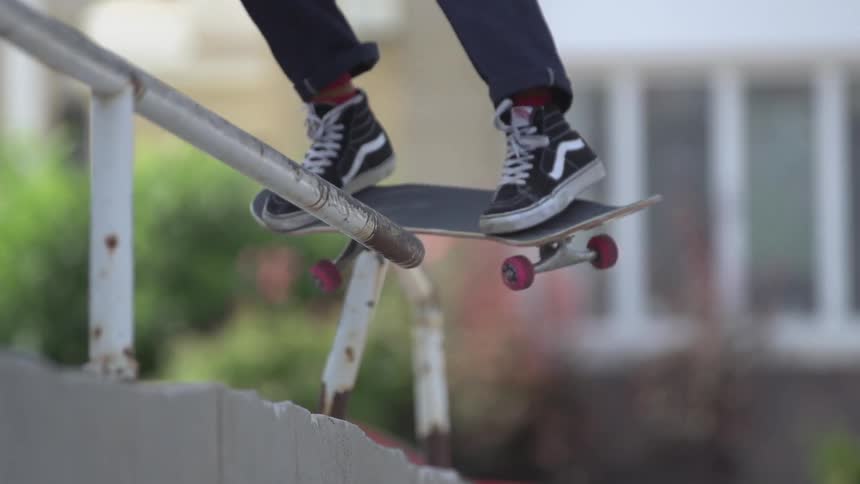 A guy jumps over a rail on a skateboard