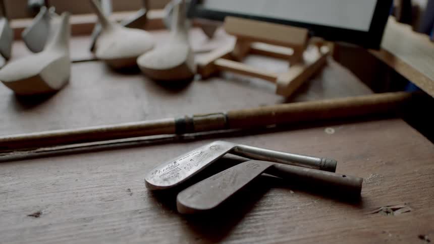 Golf club heads lying on a wooden table
