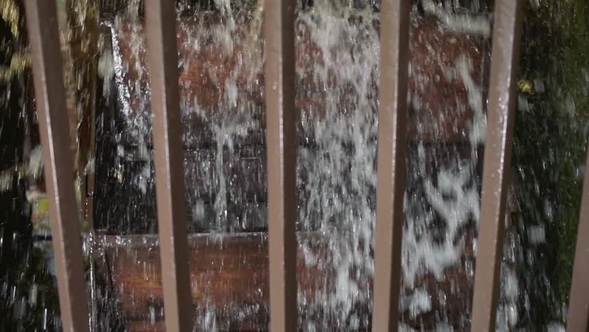 A water wheel turns and spills water