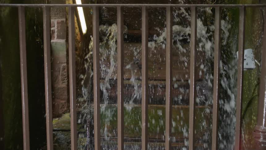Water wheel rotating with water splashing off of it