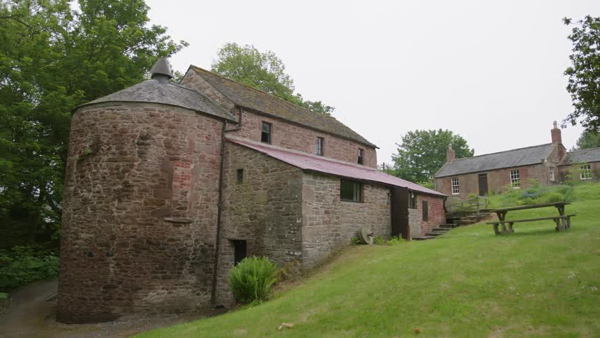 The stone buildings are on the green hill