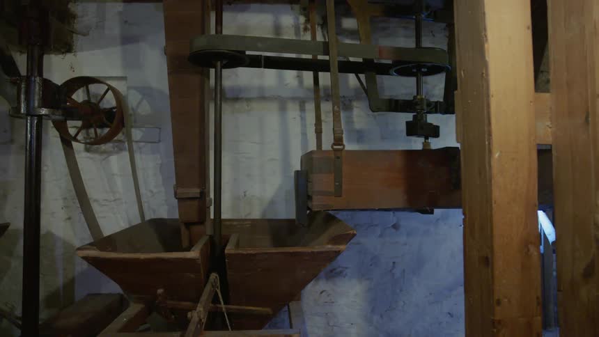 A wooden machine turns in a warehouse room