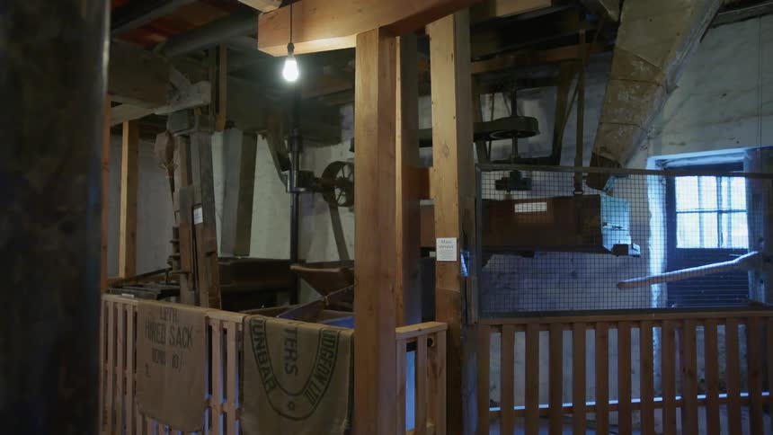 Empty stall in a barn with a light bulb hanging overhead