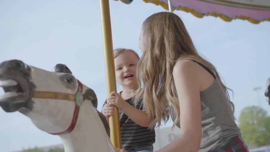 A mother and child ride the merry go round together