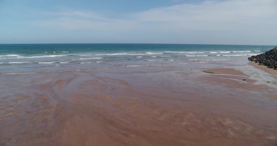Waves flow onto the beach shore