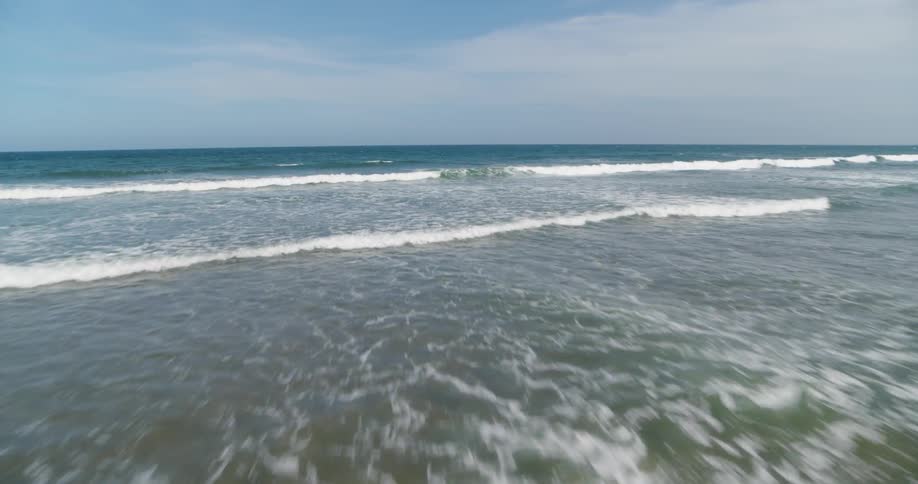 Waves flow onto the beach shore