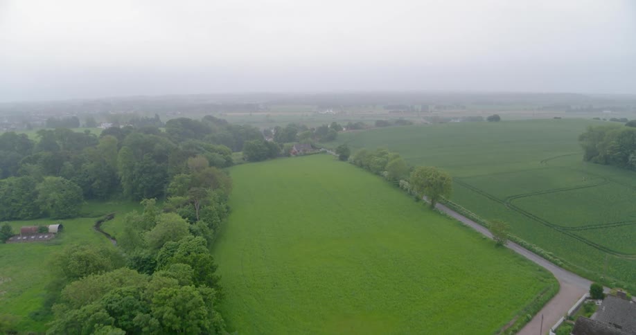 The long green fields lead to a lot and homes