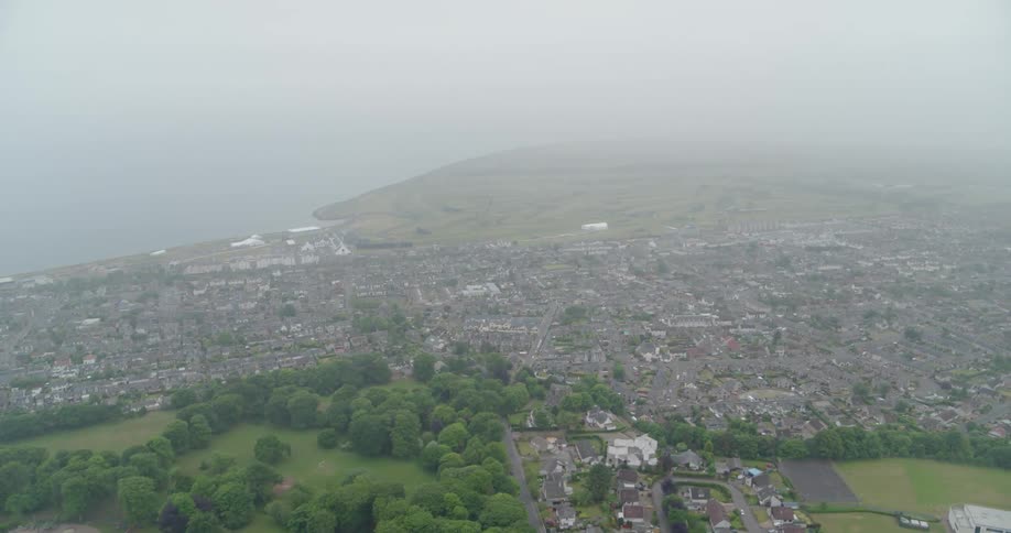 A coastal city is shown on a foggy day
