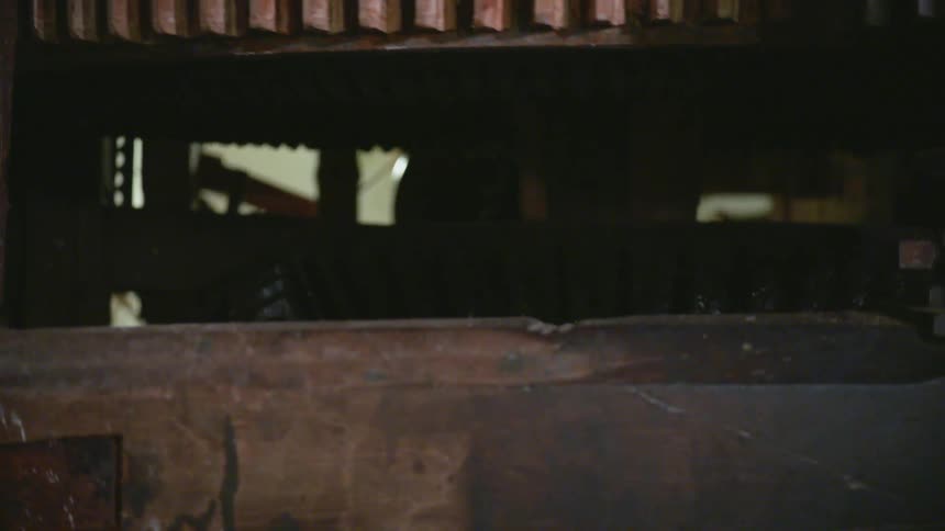 Piece of machinery with large gears turning together indoors