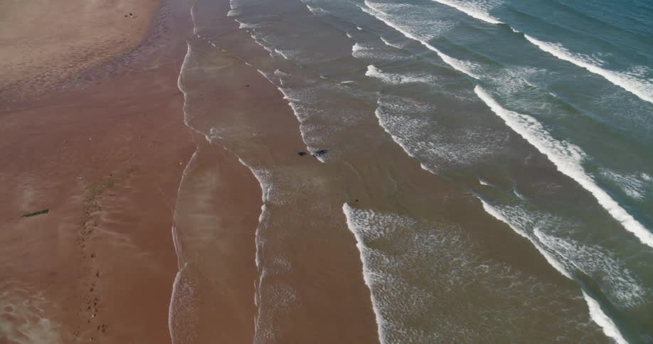 Ocean waves wash ashore a sandy beach