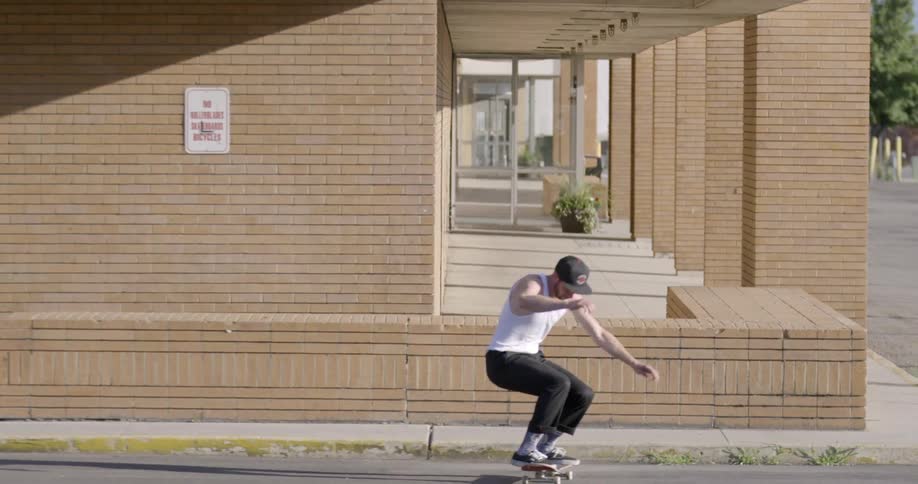 Man jumps over bricks on a skateboard on a sunny day