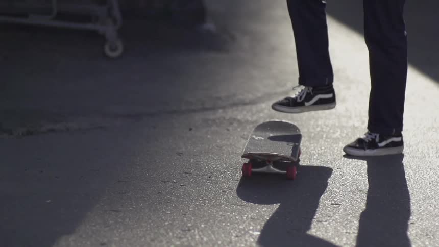 Person kicks his skateboard into his hand