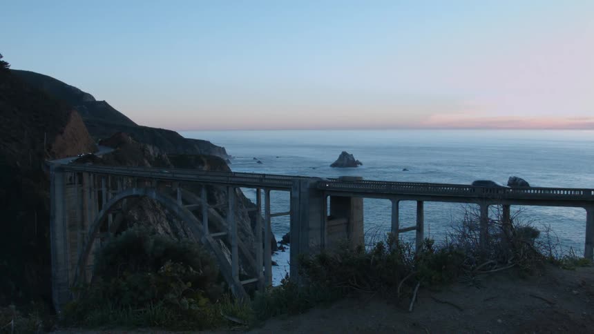 Vehicles travel over a bridge on the coast