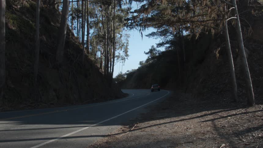 A vehicle travels up a mountain road
