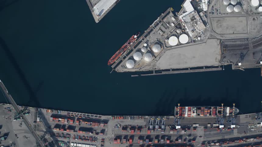Traffic crosses a bridge over an industrial harbor