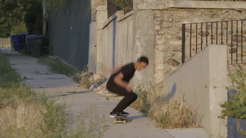 Man riding his skateboard does a jump on a sunny day