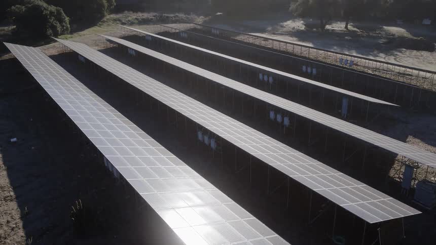 Solar panels sit in a rural field