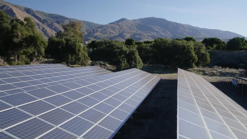 Solar panels sit in a rural field
