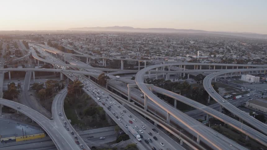 Cars drive on a city freeway at sunset