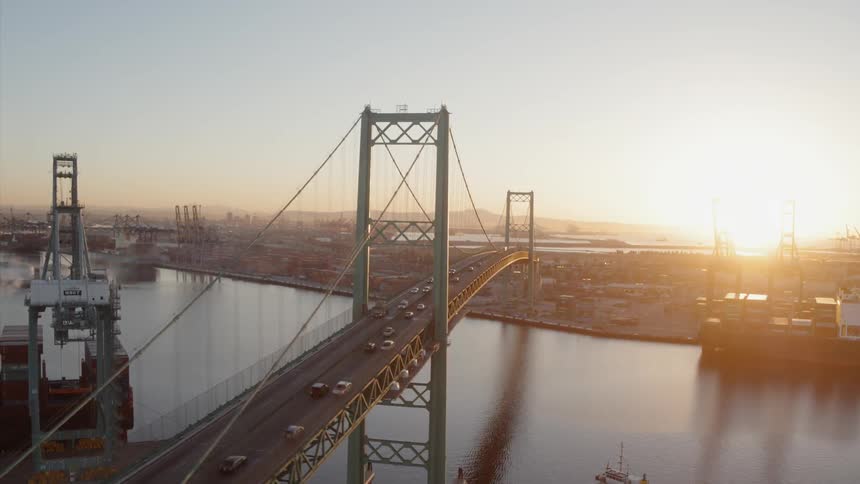 Cars drive on a city bridge at sunset