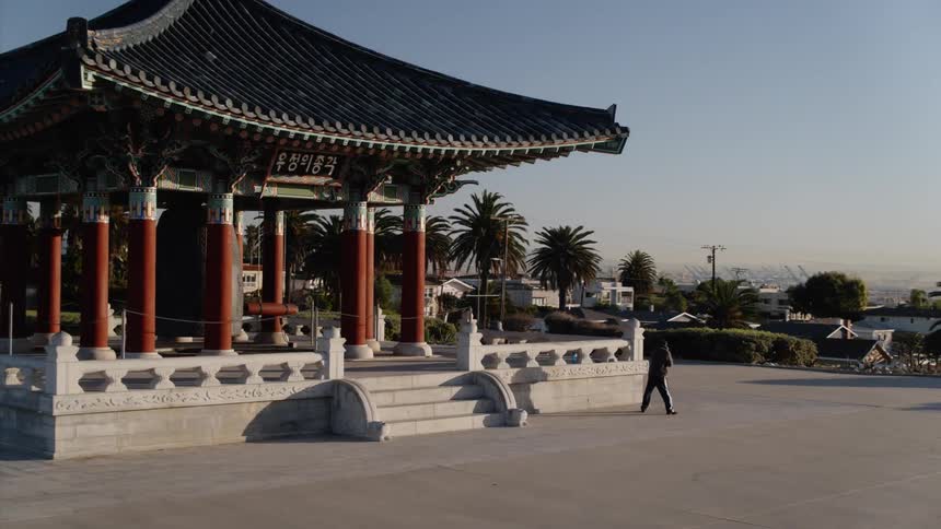 A man shadow boxes outside of a monument