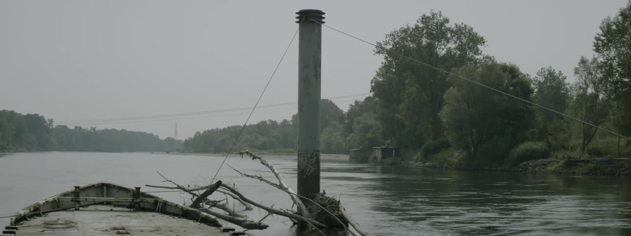 A large concrete pillar is standing in the middle of a river