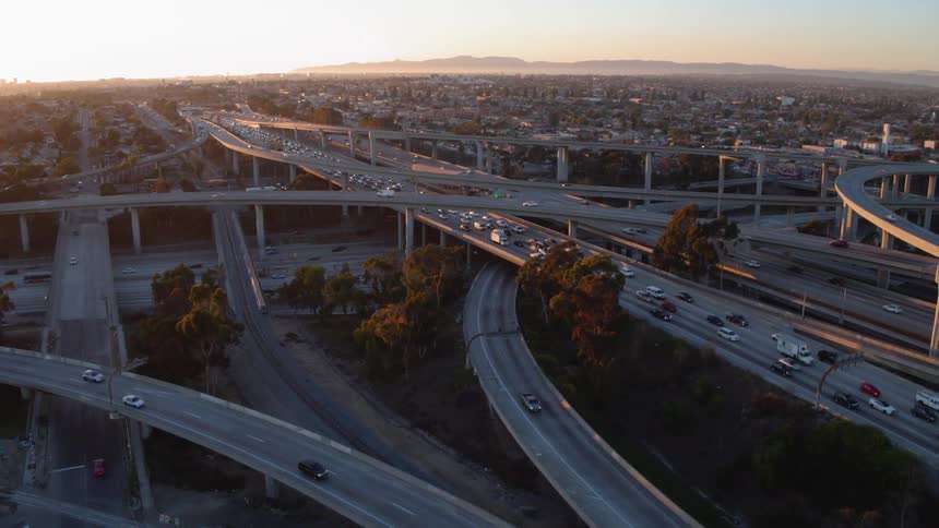 Cars drive on a city freeway at sunset